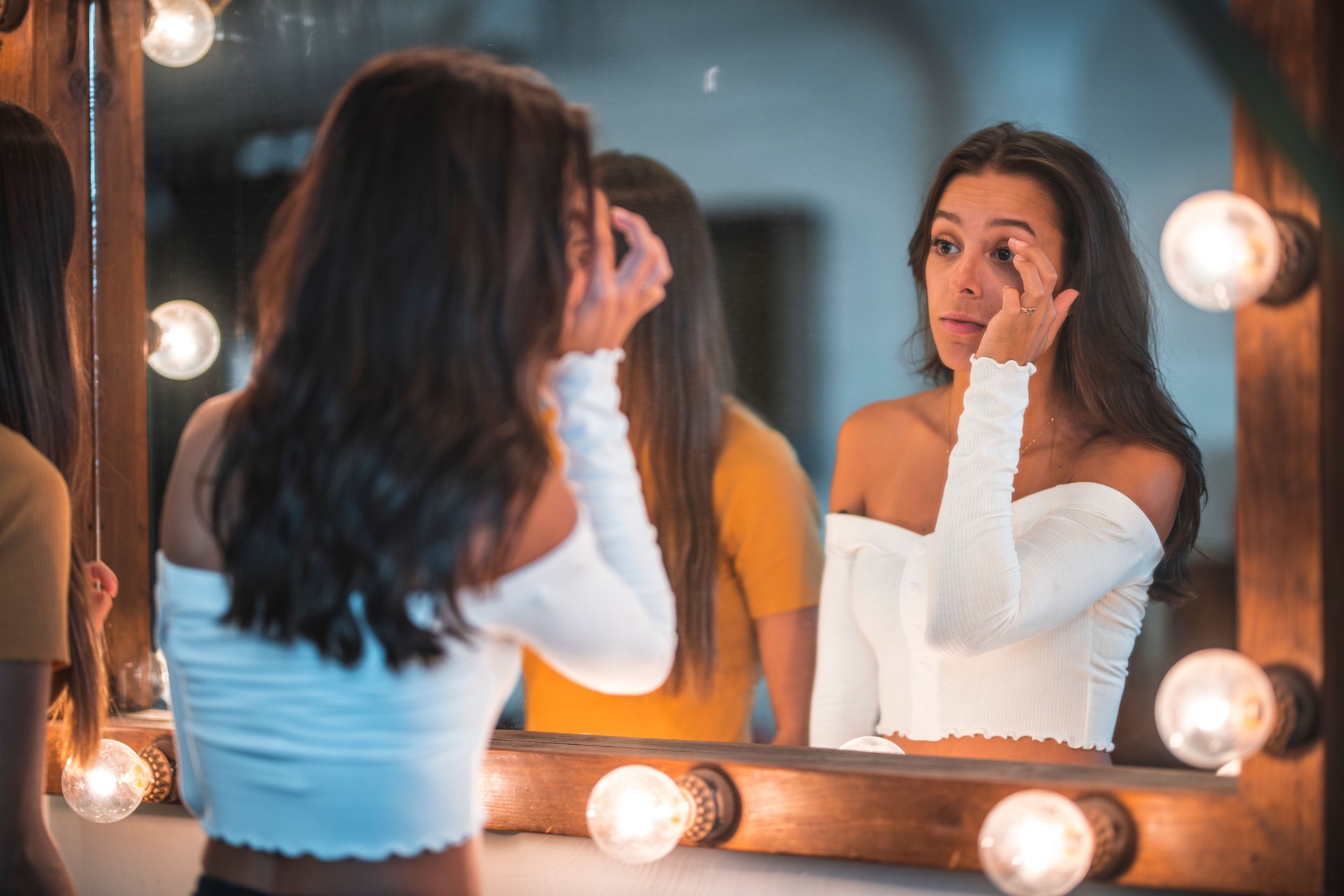 Young friends looking in mirror at home